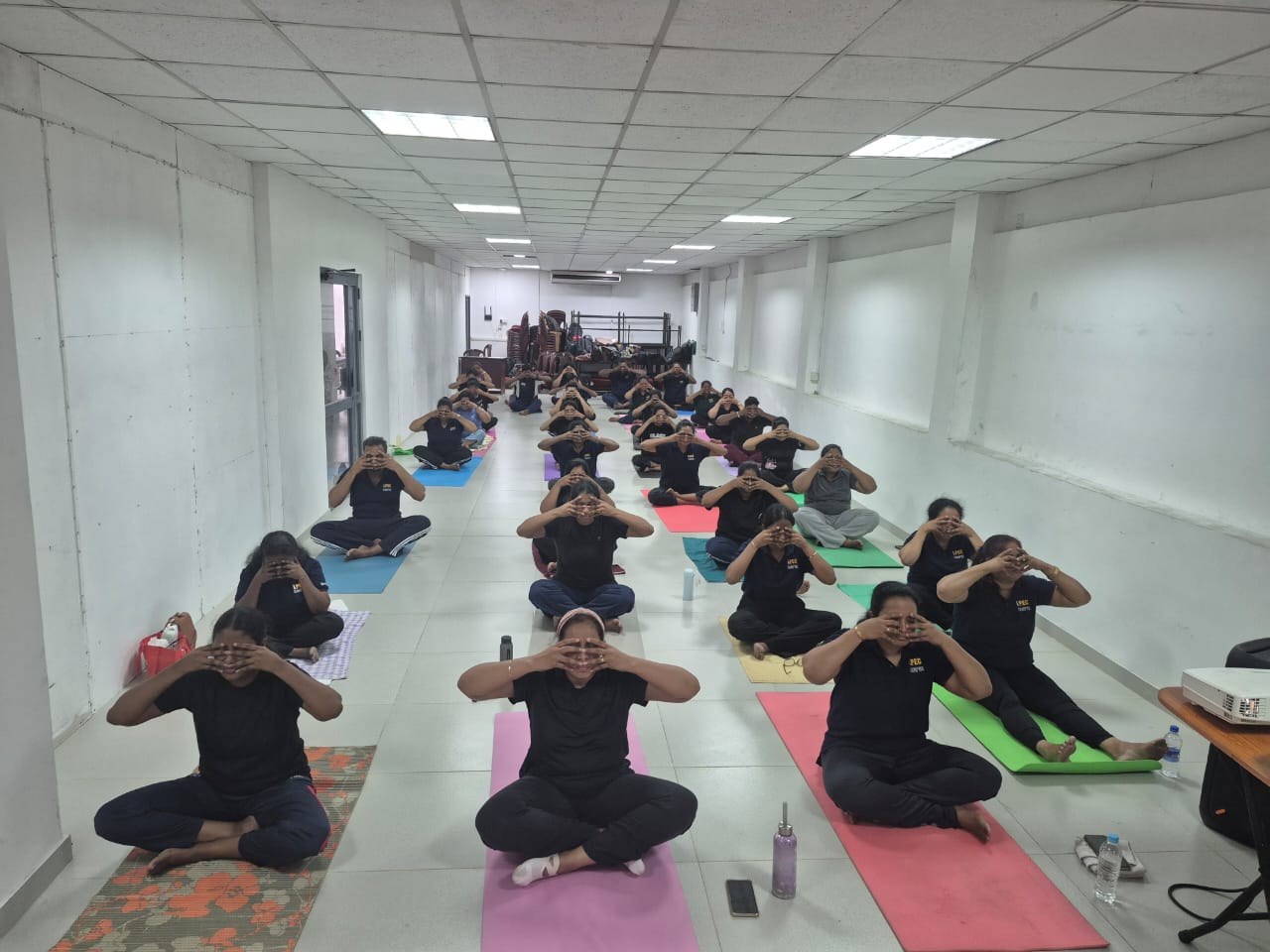 Workplace yoga class practising a face-covering mudra